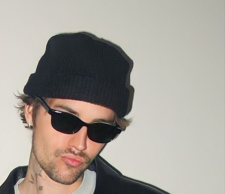 Two caps and a folded beanie arranged on a neutral background